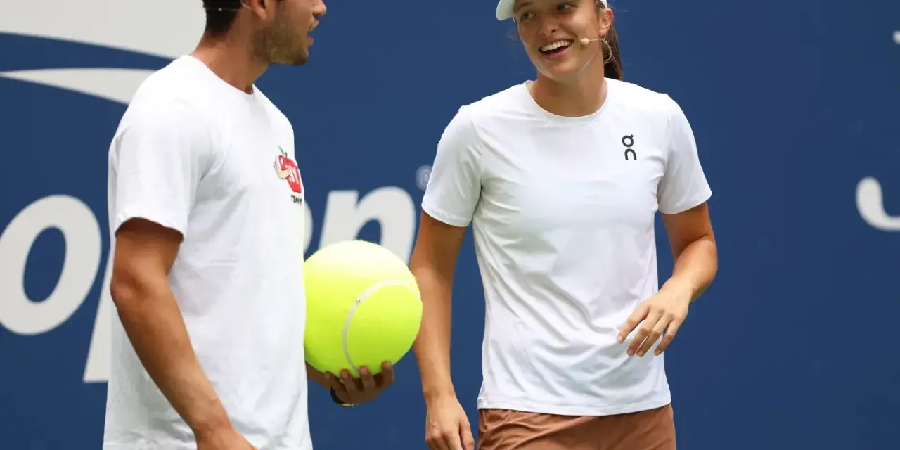 Carlos Alcaraz i Iga Świątek rozmawiają podczas Roland Garros 2024. Carlos trzyma wielką piłkę tenisową.