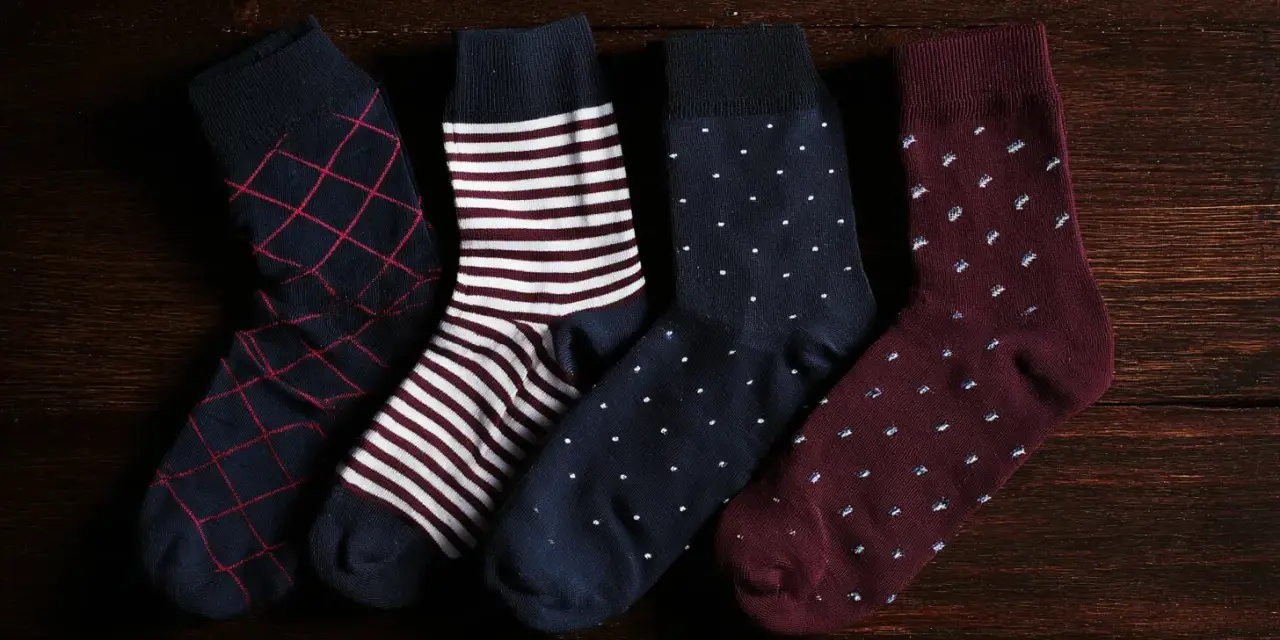 Quattro paia di calzini da uomo con fantasie diverse: rombi, righe, pois. Perfetti da abbinare a un abito elegante.
