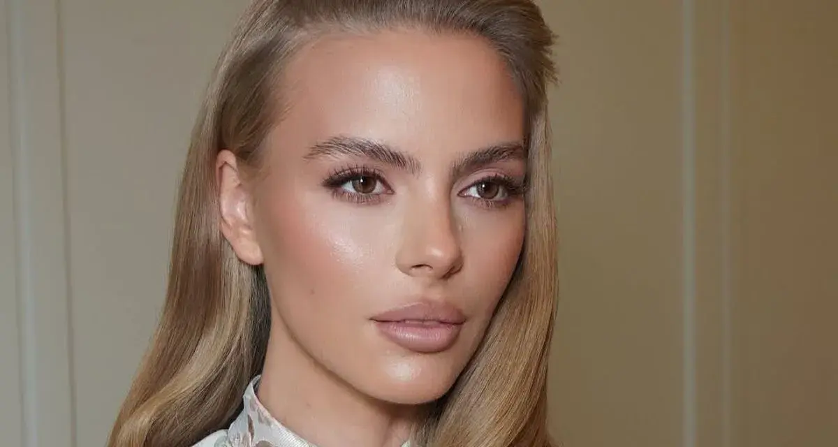 Delikatny makijaż podkreśla urodę kobiety, a jej skóra ma subtelny, **kolor perłowy** blask.