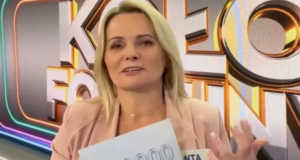 Kobieta z Koła Fortuny trzyma kartę z napisem "00000", zastanawiając się, co daje złota karta w kole fortuny.
