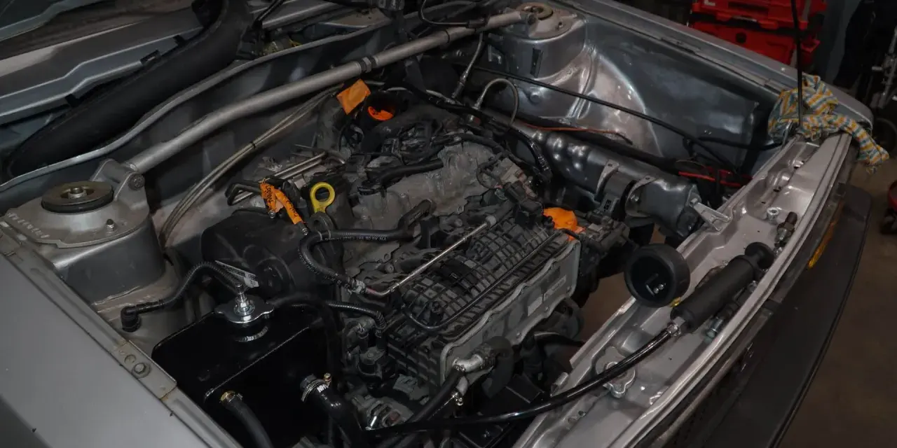 Silnik 1.8T z widocznym zaworem odmy. Sprawdzanie objawów awarii układu odpowietrzania silnika.