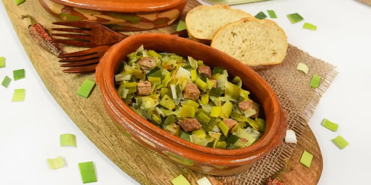 Zwei Terrinen mit Lauchgemüse und Fleischstücken, serviert mit Brot. Ein leckeres Beispiel für Lauch Rezepte.