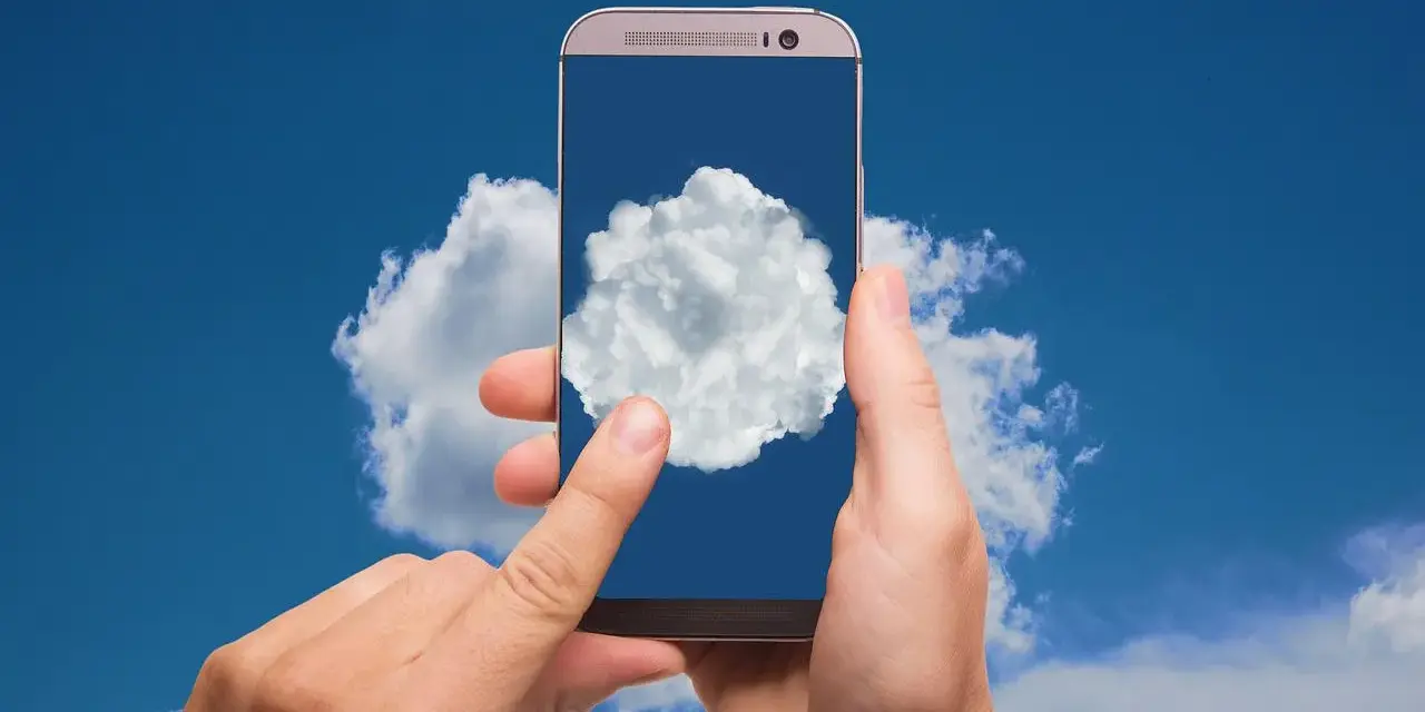 Dłonie trzymają telefon, na którego ekranie widać chmurę. Czy to właśnie tam jest chmura w telefonie?