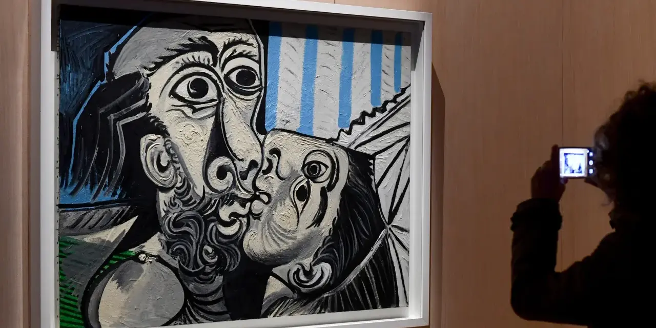 Un visitante captura con su móvil uno de los icónicos cuadros de Picasso, un beso en blanco y negro con toques de azul.