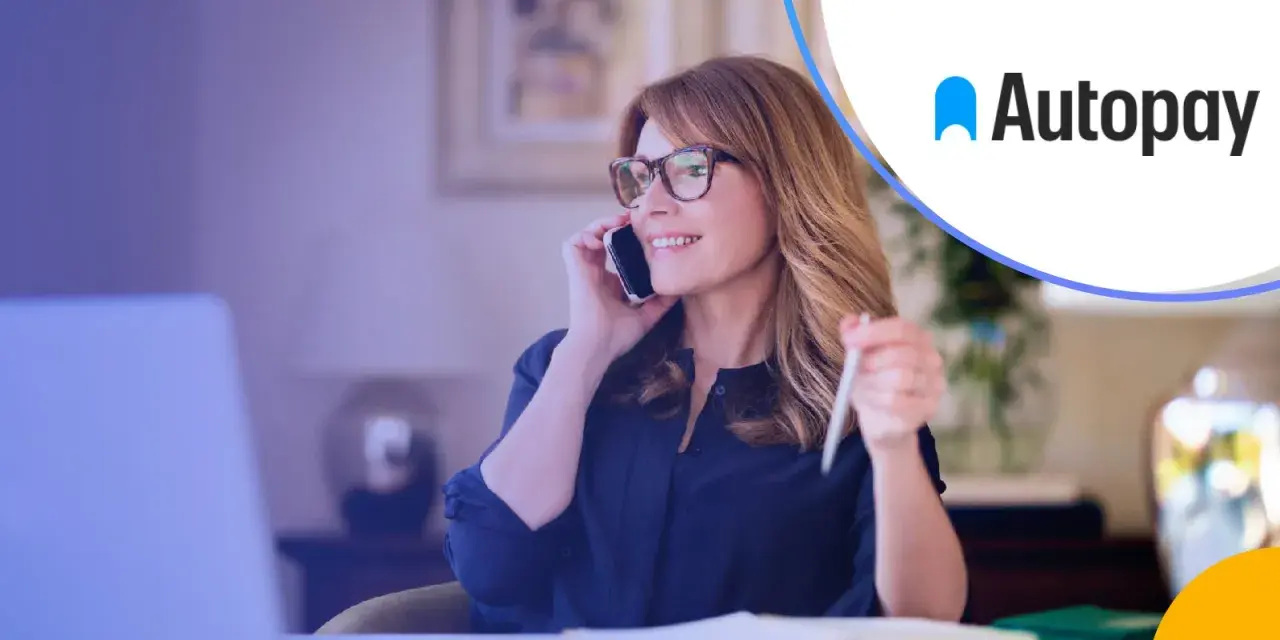 Kobieta rozmawia przez telefon, trzymając długopis. Logo Autopay obok. Dowiedz się, autopay co to jest.
