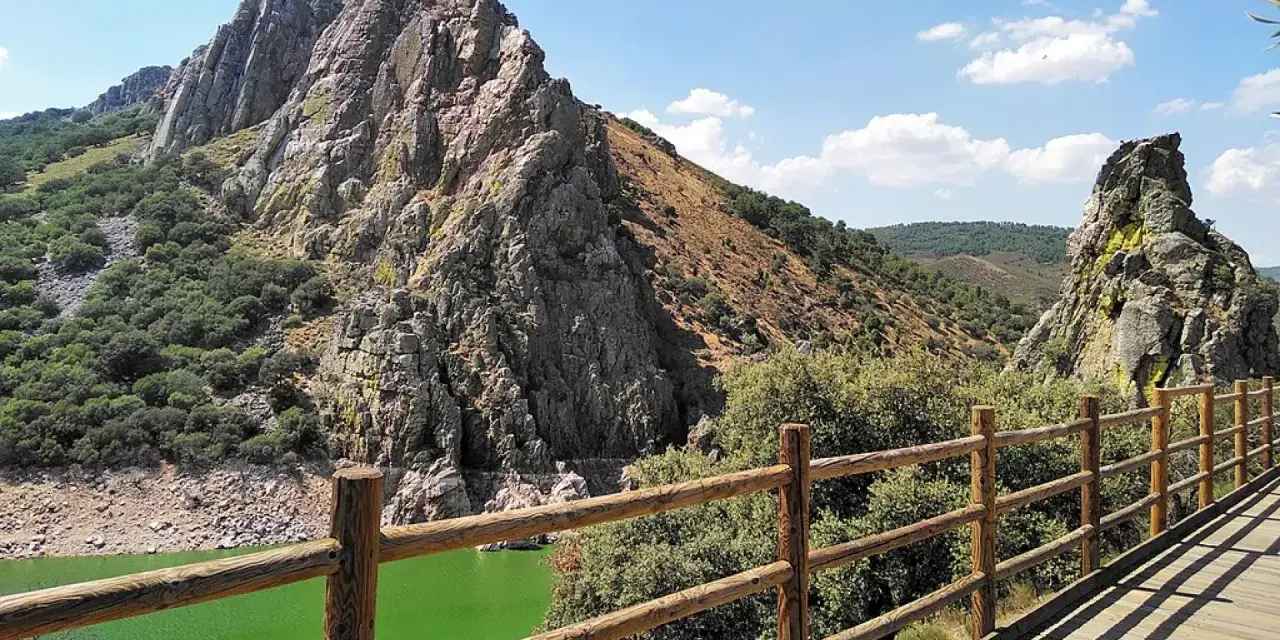 Impresionante paisaje de un parque protegido con imponentes rocas, vegetación frondosa y un río de aguas verdes.