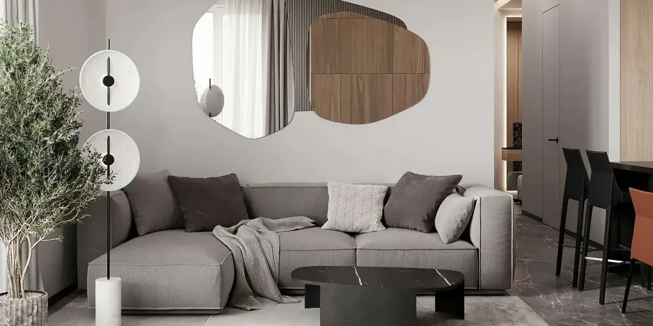 Nowoczesny salon z szarą sofą, geometrycznym lustrem i designerską lampą.