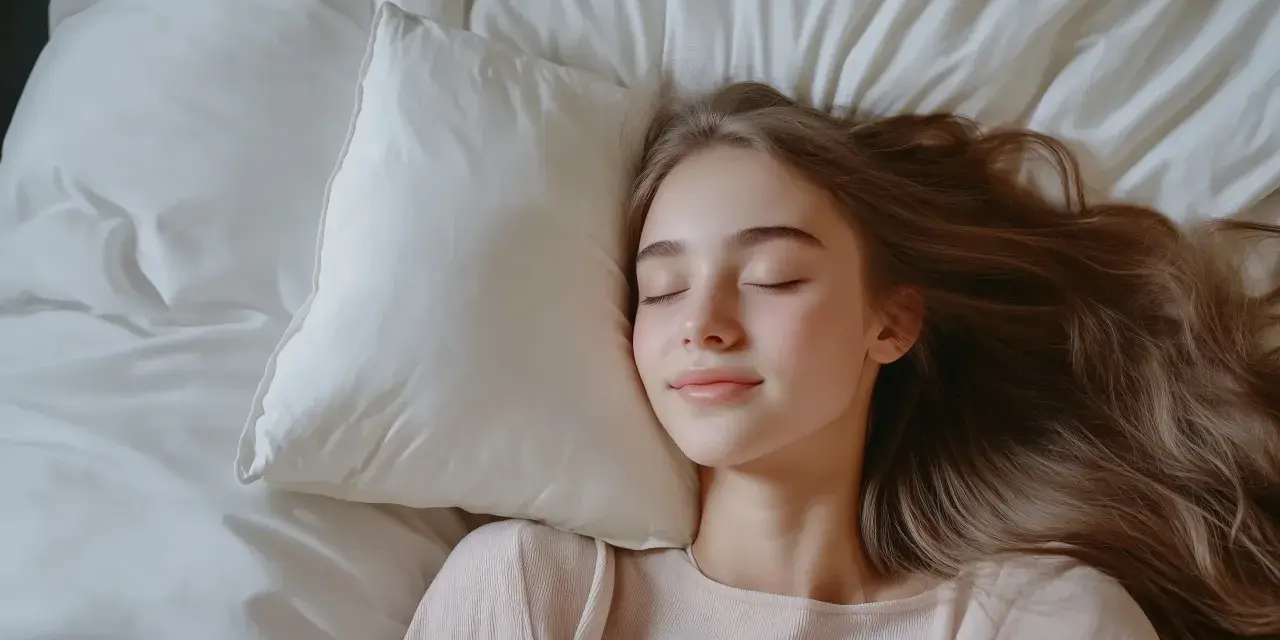 Spokojny sen dziewczyny na poduszce, symbolizujący **regulowanie emocji** i odpoczynek.