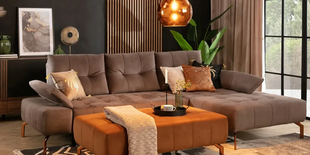 Elegancki salon z sofą w kolorze taupe, który jest pięknym odcieniem brązu z szarym akcentem. Wygodny narożnik i pufa tworzą przytulną przestrzeń.