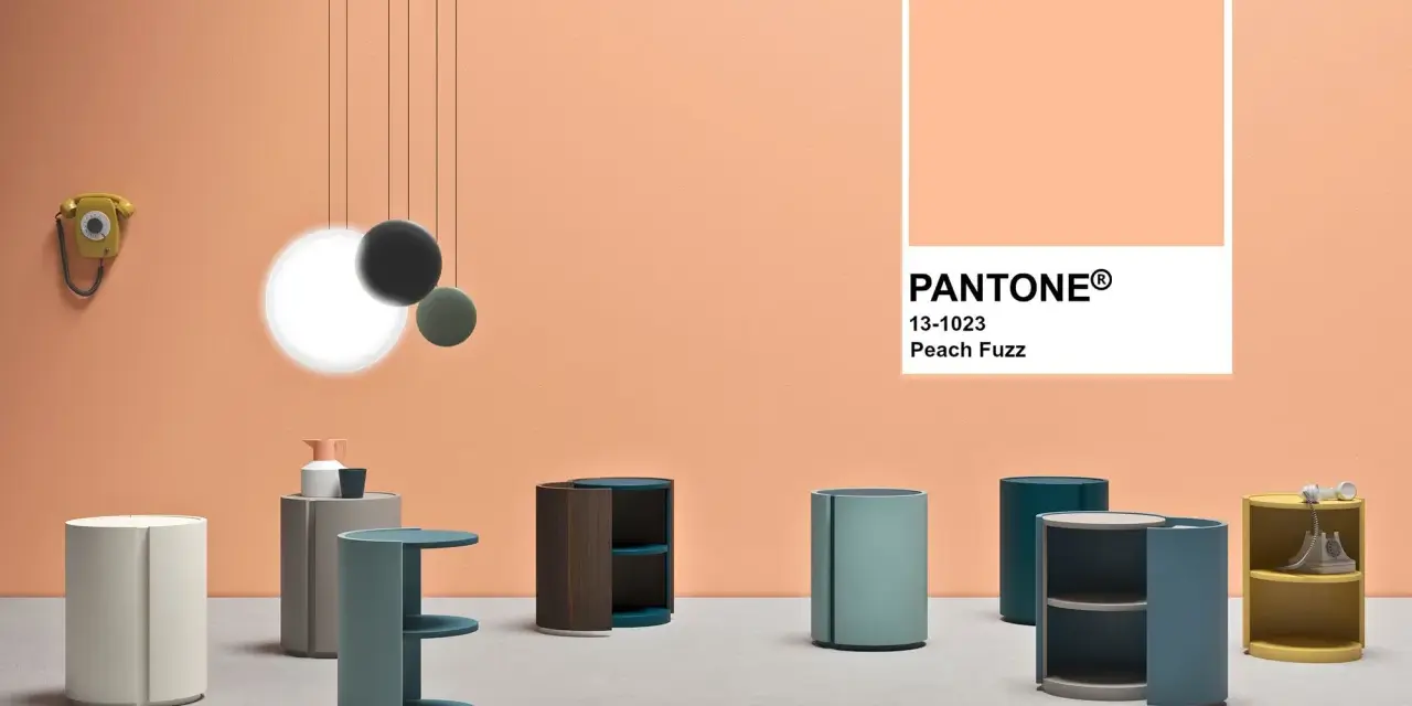 Arredamento moderno su sfondo color pesca Pantone. Tavolini cilindrici e un telefono vintage.