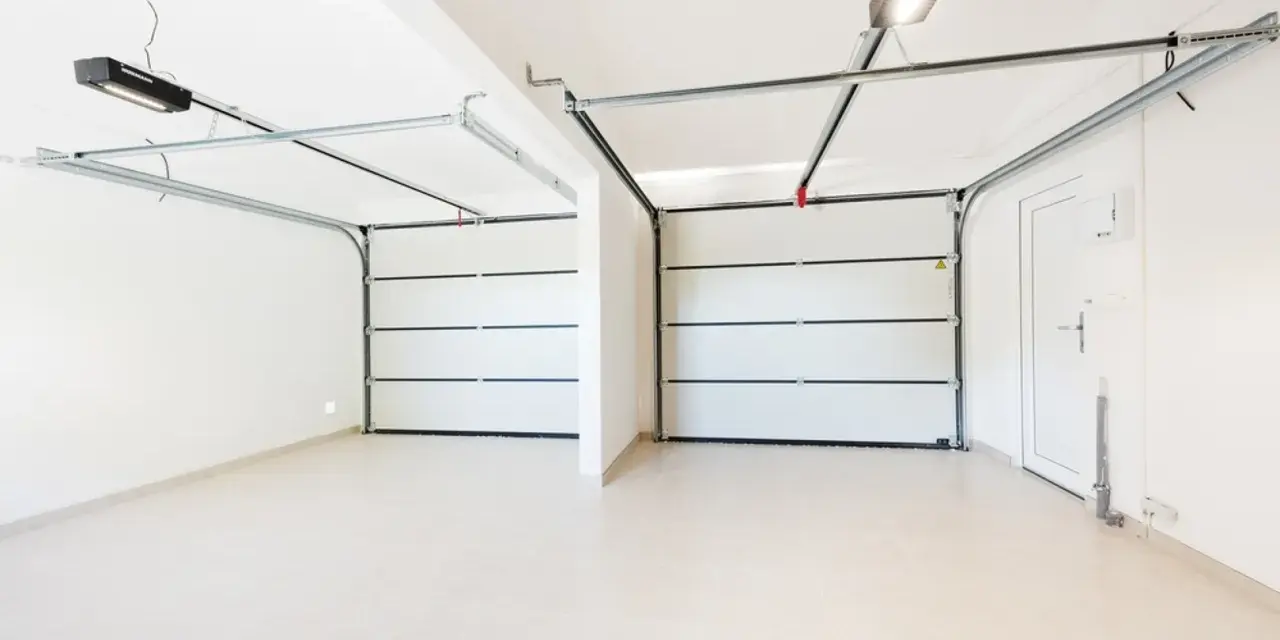 Dos puertas de garaje se abren a un espacio limpio y moderno, listo para pintar el garaje original.