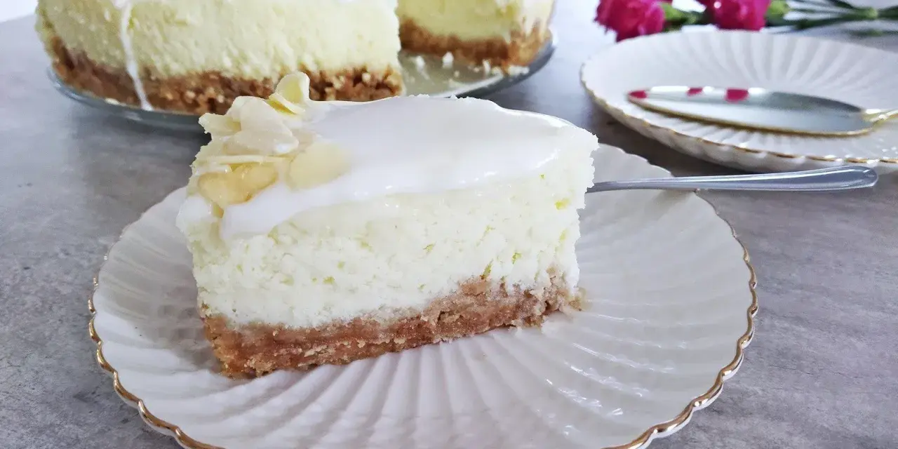 Pyszny sernik z mascarpone na kruchym spodzie, udekorowany płatkami migdałów. Idealny na deser.