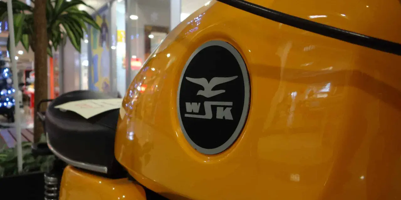 Żółty bak motocykla WSK 125 z charakterystycznym logo. Ile koni kryje się pod tą błyszczącą karoserią?