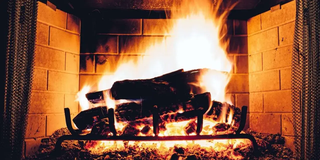 Legna che arde in un camino, con fiamme vivaci e un buon tiraggio presa aria camino che alimenta il fuoco.