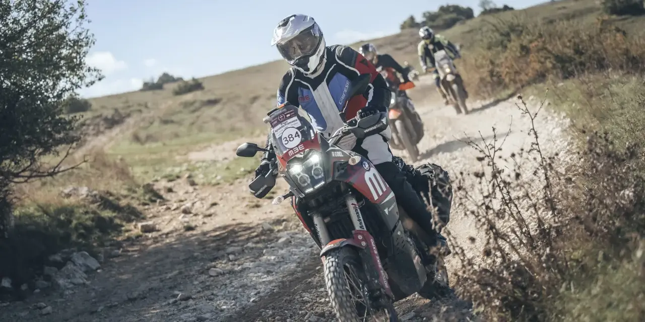 Motociclisti in azione su sterrato, un'emozionante festa bikers sotto il sole.