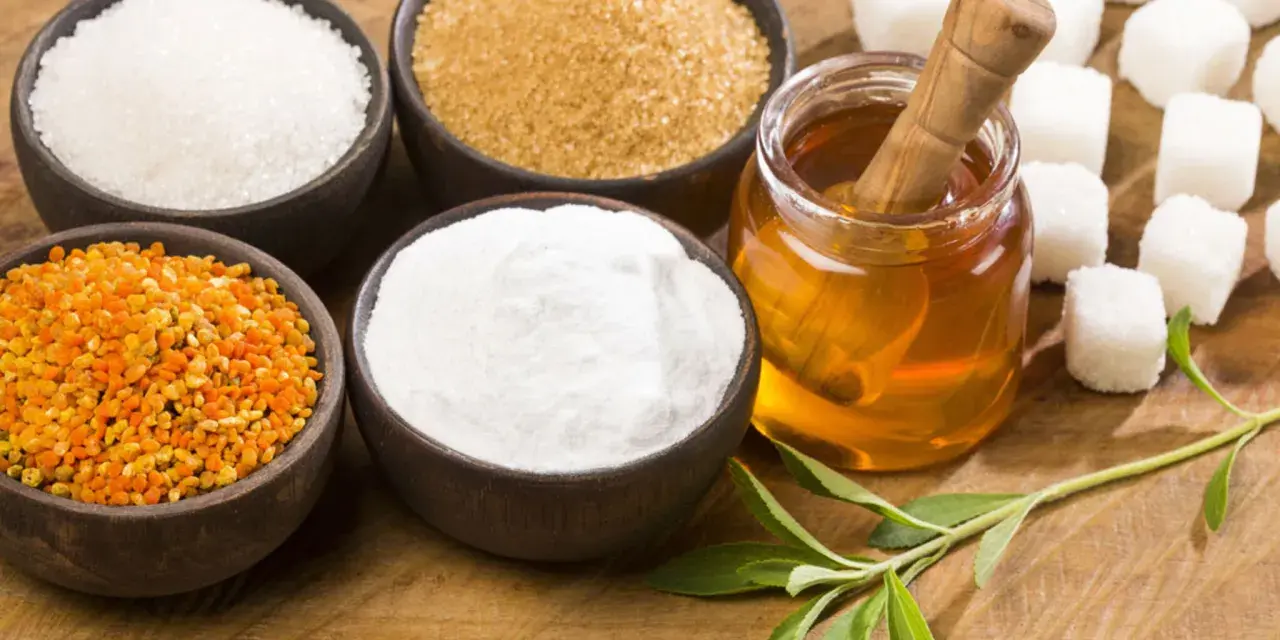 Schalen mit Zucker, Honig, Pollen und Stevia-Blättern – ideale Zutaten für zuckerersatz zum Backen.