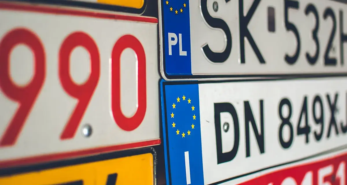 Un'opera d'arte di targhe automobilistiche europee, con numeri rossi e neri su sfondi bianchi e gialli.