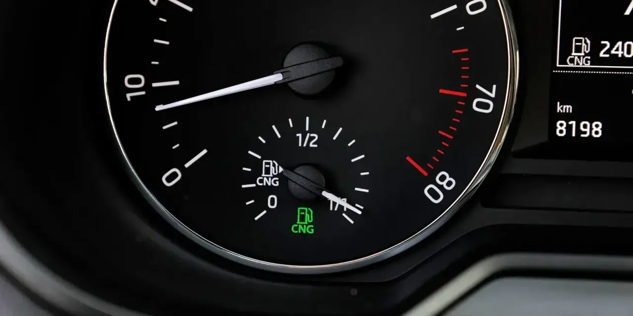 Zbliżenie na deskę rozdzielczą samochodu z wskaźnikiem paliwa CNG.