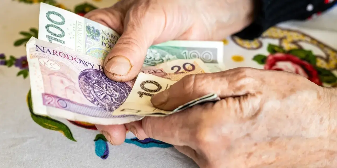 Dłonie liczą polskie banknoty. Zastanawiasz się, w jakim miesiącu najlepiej przejść na emeryturę, by mieć więcej pieniędzy?