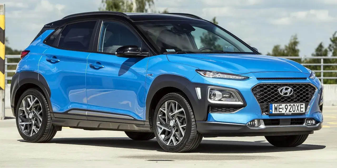 Niebieski Hyundai Kona 2025 z czarnym dachem, zaparkowany na zewnątrz.