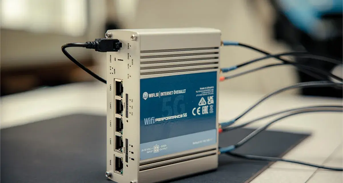 En silverfärgad 5G-router med flera LAN-portar och antennkablar. Perfekt för mobilt bredband i Europa.