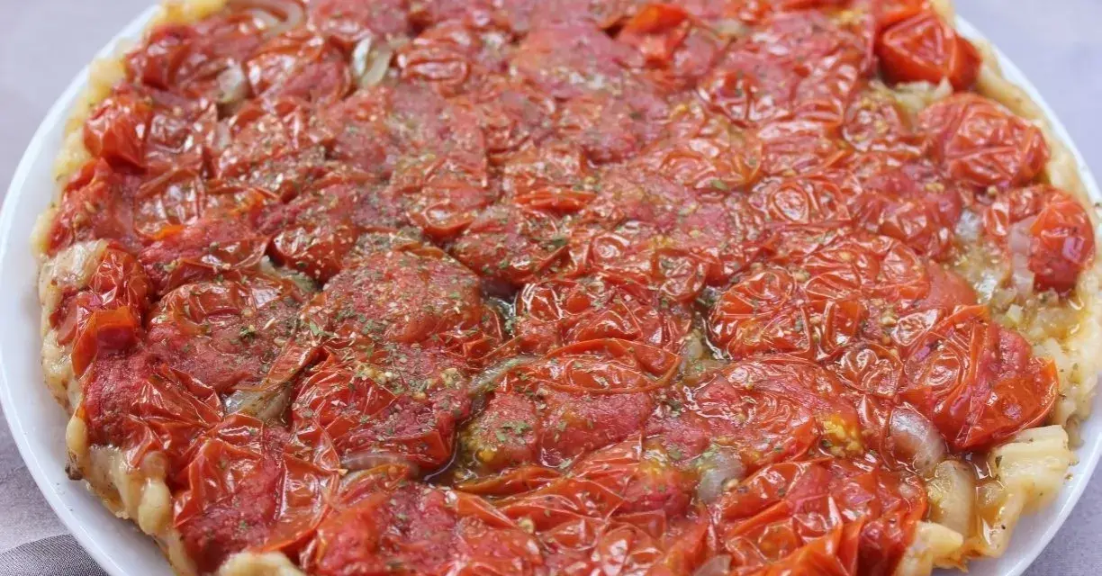 Tarte tatin di pomodorini confit, con cipolle caramellate e erbe aromatiche, un tripudio di sapori mediterranei.