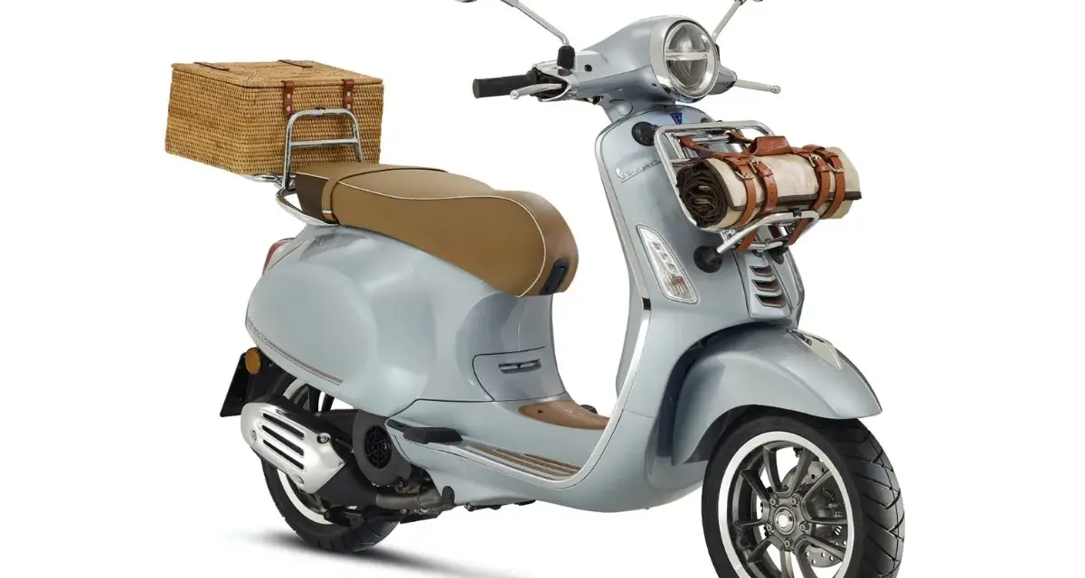 Stylowe skutery retro 125 w kolorze błękitnym, z wiklinowym koszem z tyłu i kocem z przodu, idealne na piknik.