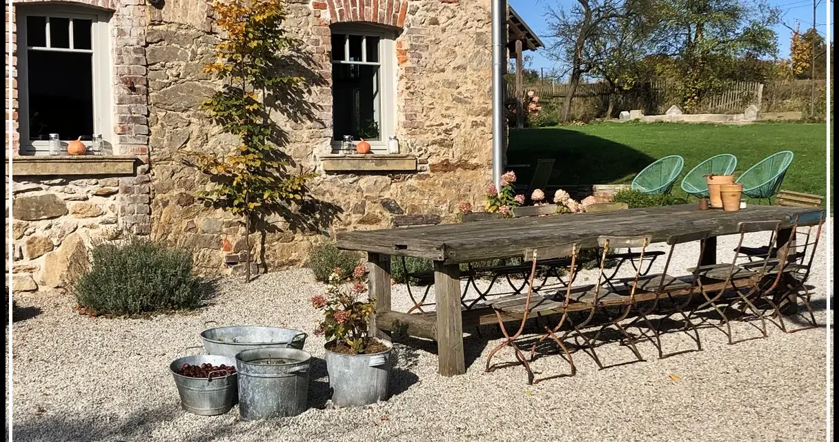 Rusty metal chairs await guests at a rustic table, perfect for enjoying the charm of agroturystyka Dolny Śląsk.
