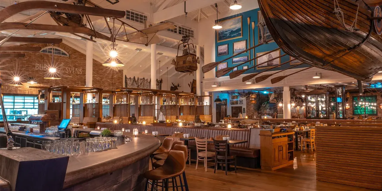 Das Restaurant Bubba Svens ist im maritimen Stil eingerichtet, mit einem Boot über den Tischen und Paddeln an der Wand.