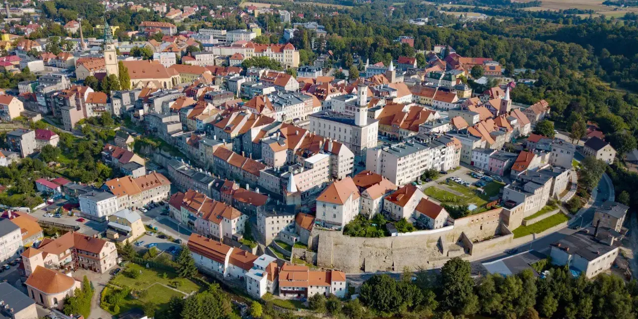 Bystrzyca Kłodzka atrakcje: malownicze miasto z zabytkowym rynkiem, kościołem i murami obronnymi, otoczone zielenią.