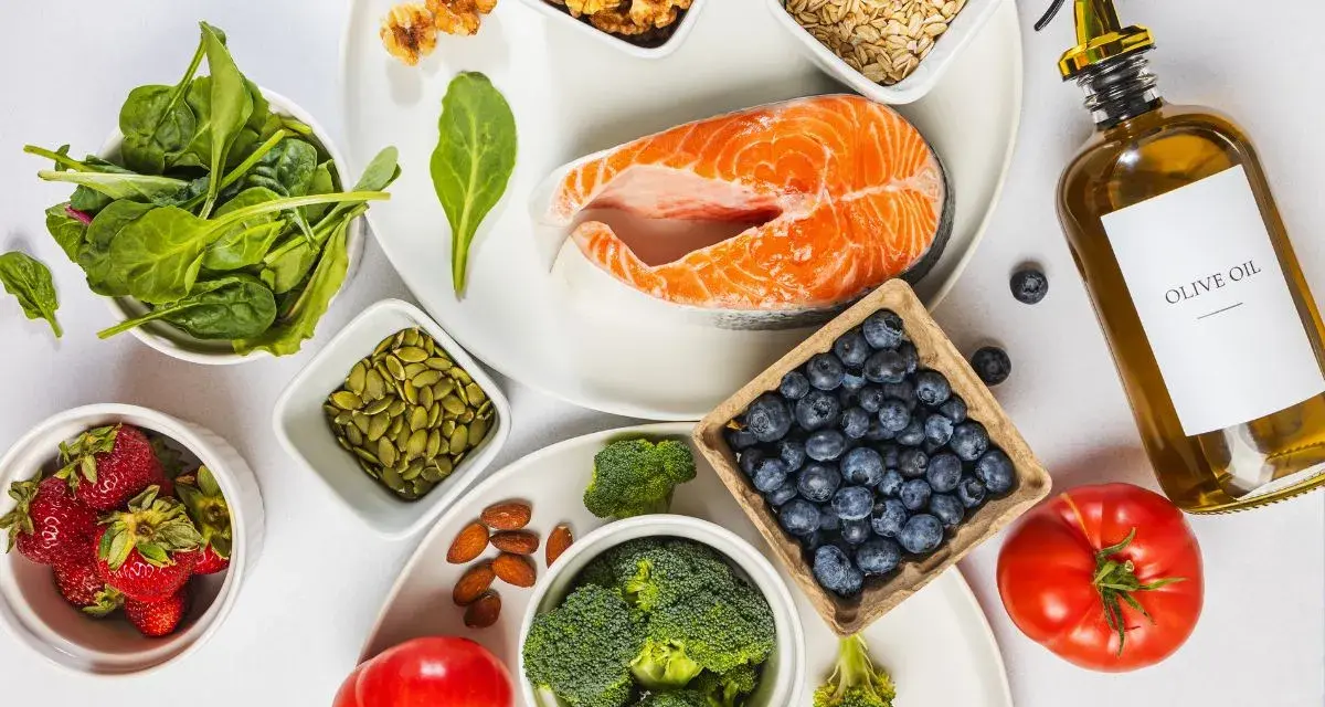 En hälsosam måltid med lax, bär, grönsaker och nötter. Denna inflammation mat är rik på omega-3 och antioxidanter.