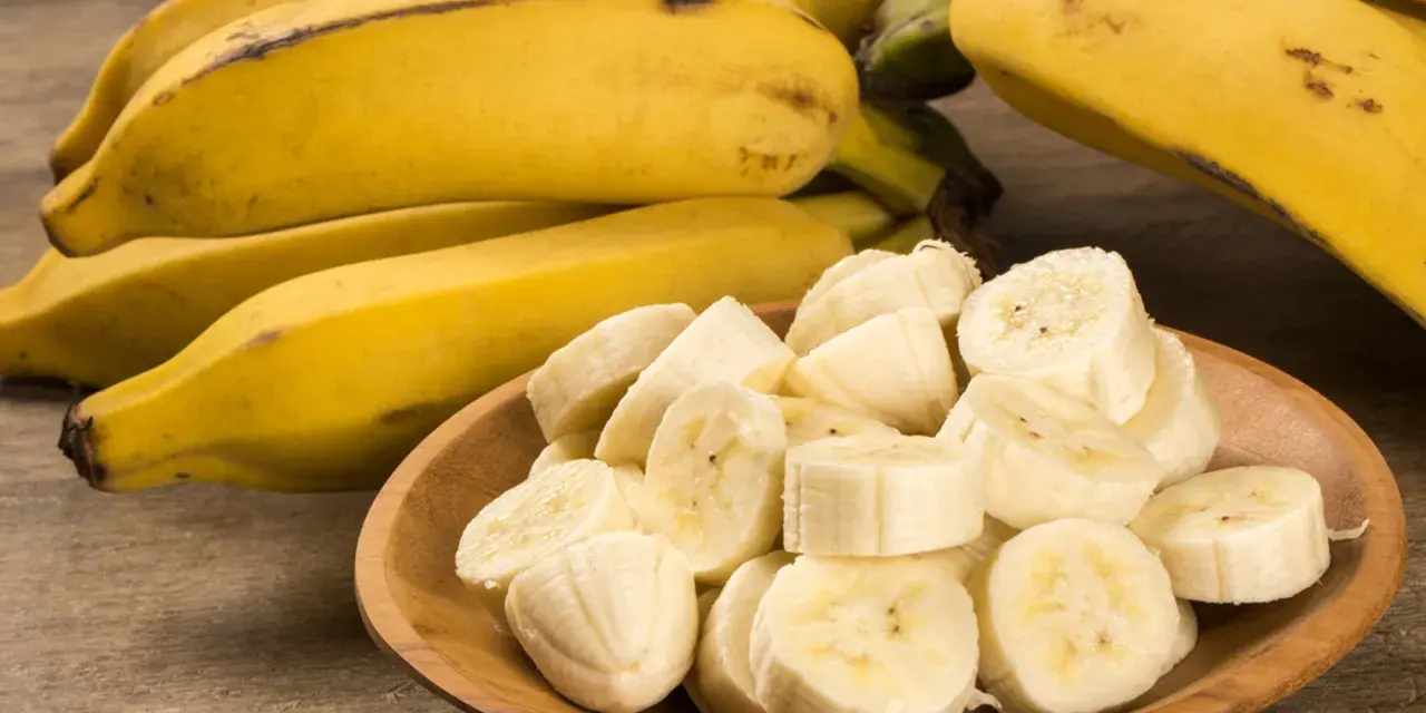Kawałki banana na drewnianej desce. Banan wartości odżywcze to potas i witaminy.