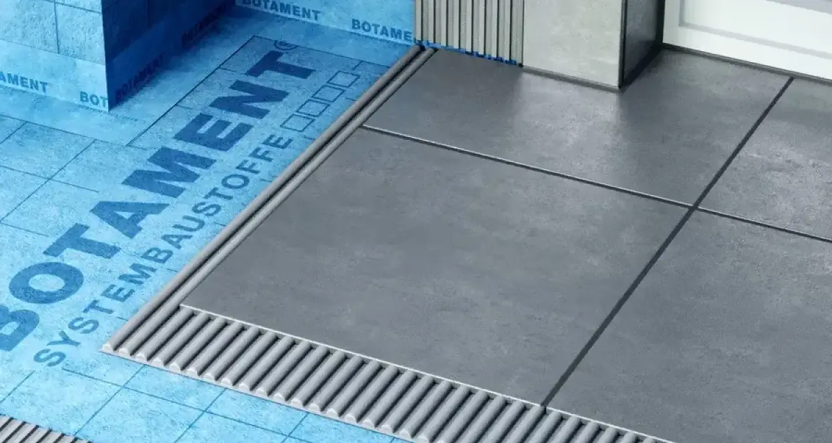 Systemowa hydroizolacja łazienki z niebieską membraną Botament i szarymi płytkami.
