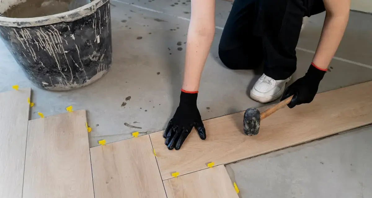 Instalando baldosas de madera, el mejor suelo para garaje particular. Se usa mazo y niveladores.