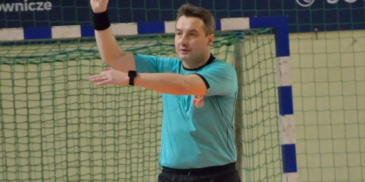 Sędzia Paweł Podsiadło pokazuje dwa palce, sygnalizując wynik meczu.