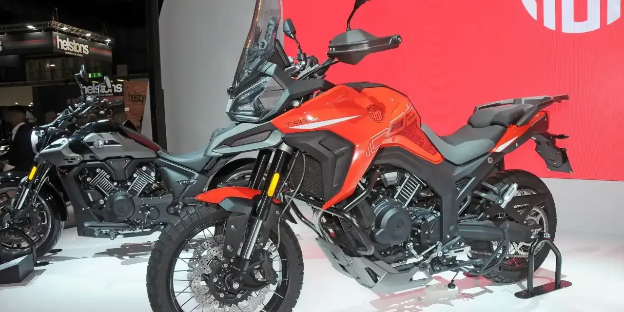 Pomarańczowy motocykl Morbidelli T1002VX na wystawie, gotowy na przygodę. Obok stoi jego szary brat.