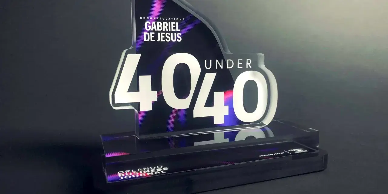 A "40 Under 40" award for Gabriel De Jesus, showcasing how strong is acrylic. The award features a sleek, modern design with vibrant purple and pink accents.