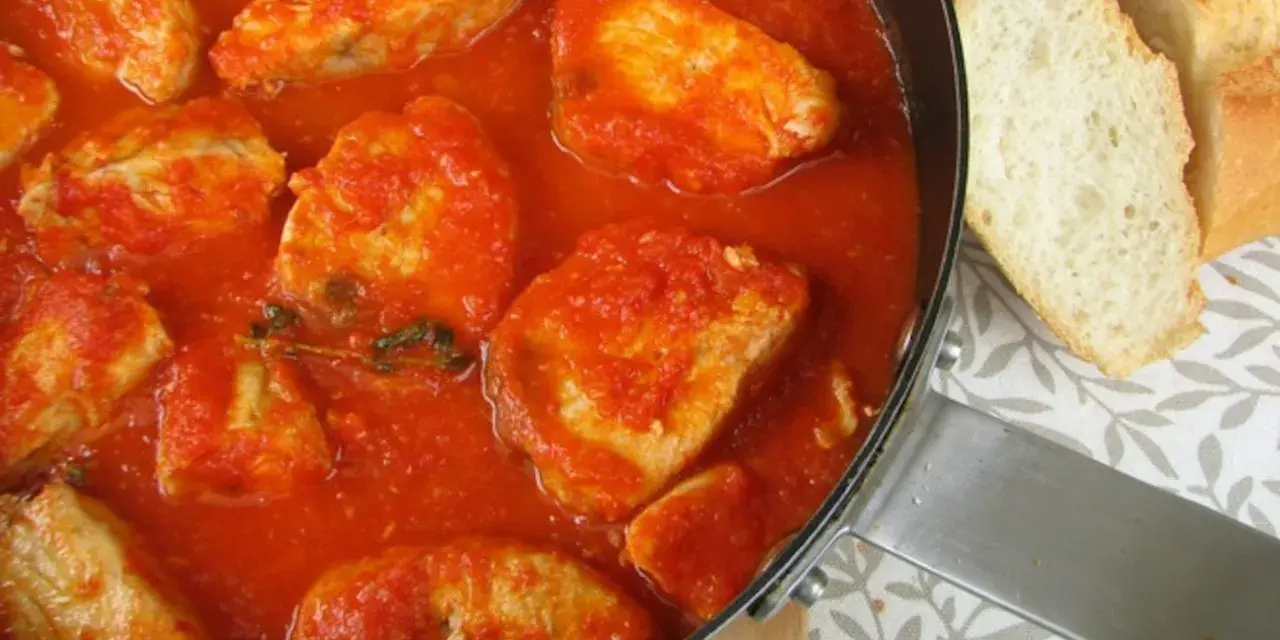Sabroso pollo en salsa de tomate, como la receta de la abuela. Acompañado de pan crujiente.