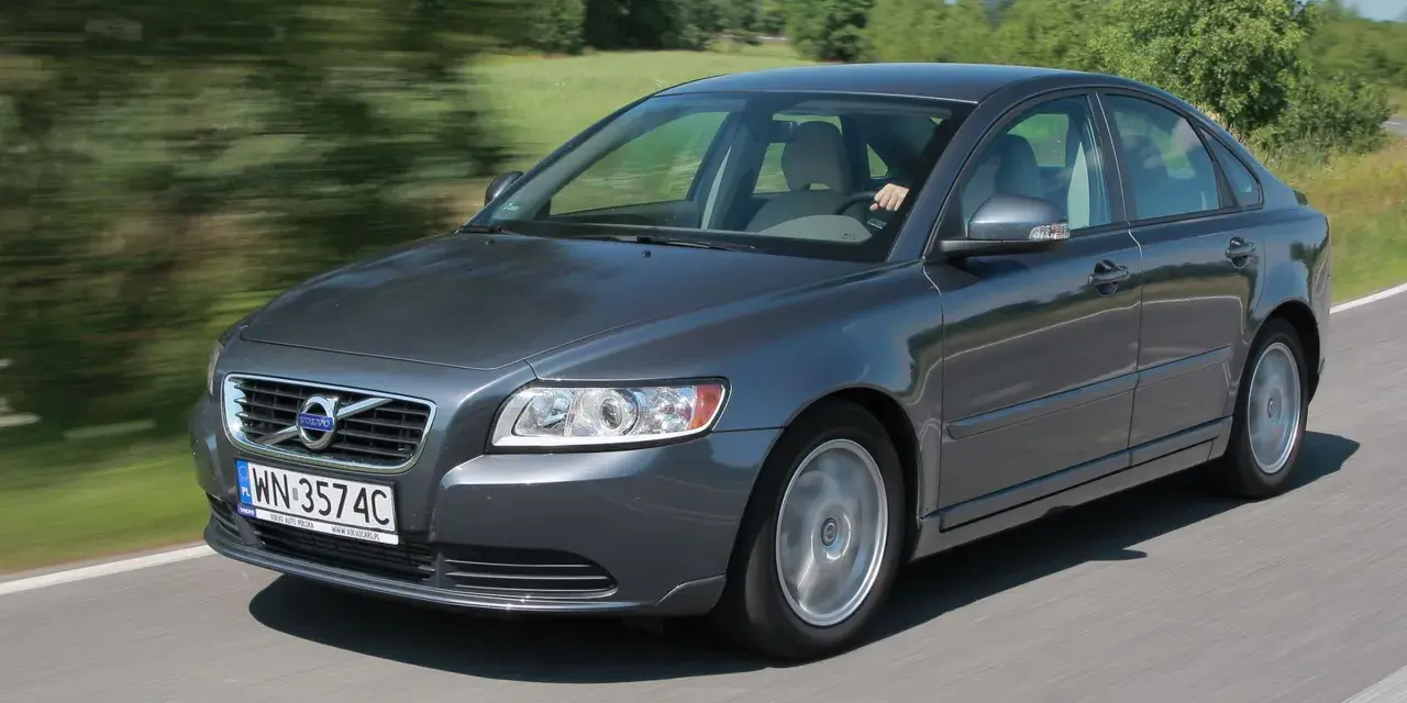 Szary Volvo S40 2.0 diesel w ruchu, z rozmazanym tłem zieleni i drogi.