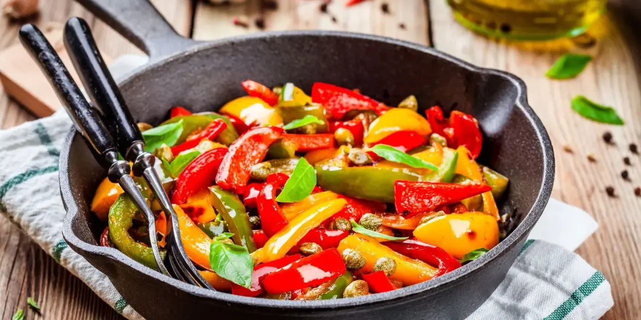 Peperoni in padella, colorati e succosi, pronti per essere gustati. Un contorno semplice e saporito.