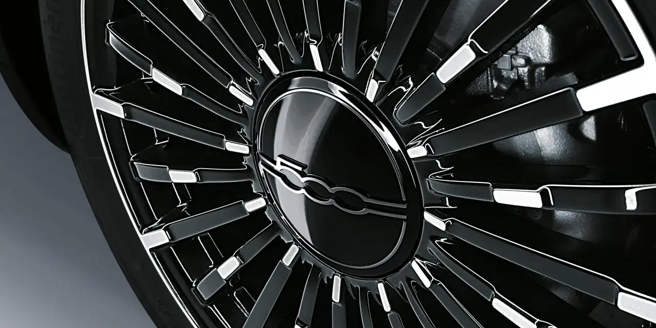 Cerchio in lega nero lucido con logo Fiat centrale, dettaglio per la pressione gomme Fiat 500L.