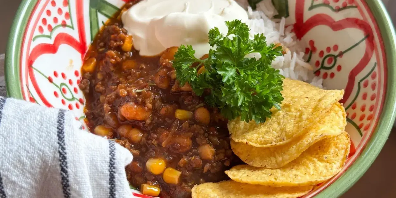 En skål med chili con carne, ris, gräddfil och tortillachips. Perfekt vin till chili con carne!
