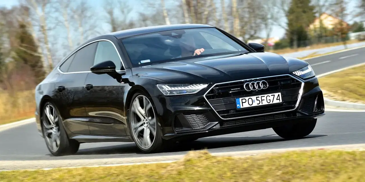 Czarny Audi A7 na drodze. Sprawdź aktualną audi a7 cena i możliwości tego sportowego sedana.
