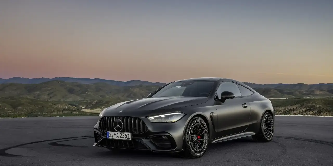 Mroczny Mercedes CLE 53 AMG na tle górskiego krajobrazu o zachodzie słońca.