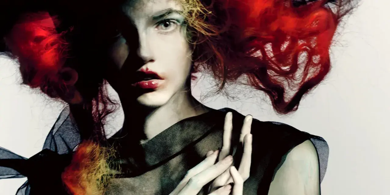 Portret kobiety z ognistymi włosami i czarną siatką, w stylu Paolo Roversi.