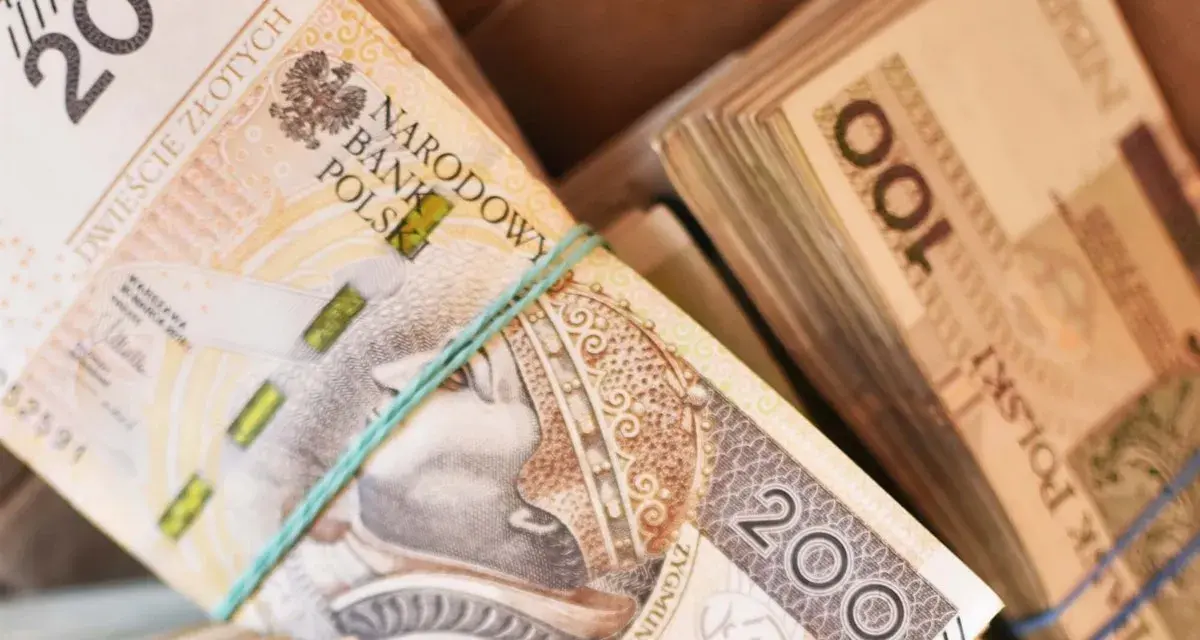 Stosy polskich banknotów 200 zł i 100 zł. Zastanawiasz się, ile zarabia sprzedawca w salonie samochodowym?