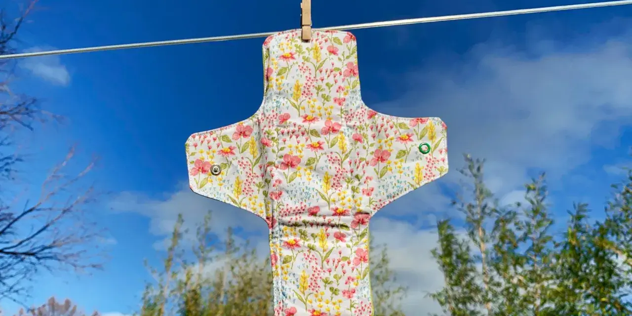 Serviette hygiénique lavable à fleurs, suspendue pour sécher. Un tuto pour la fabriquer soi-même.
