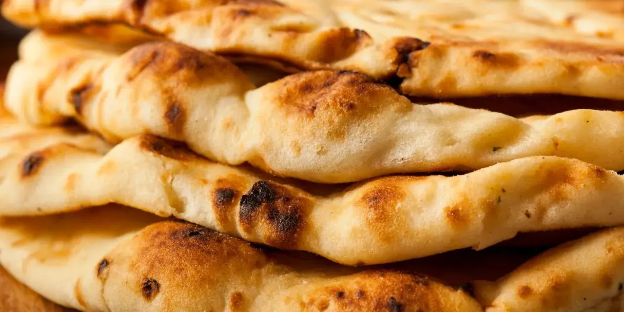 Gestapeltes, frisch gebackenes Naan Brot mit leichten Röststellen. Perfekt zum Dippen!