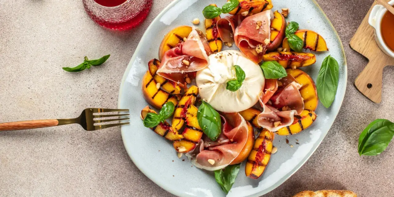 Gegrillte Pfirsiche mit cremigem Burrata, Prosciutto und Basilikum – ein köstlicher Pfirsich Burrata Genuss.