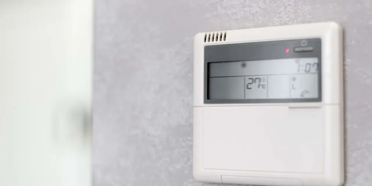 Panel klimatyzacji hotelowej pokazuje 27°C. Dowiedz się, jak ustawić klimatyzację w hotelu, by cieszyć się komfortem.
